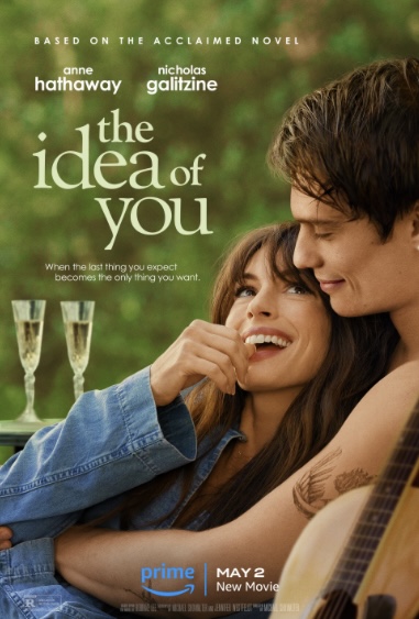Poster for "The Idea of You." Anne Hathway sits in Nicholas Galitizine's arms. They smile at each other. Glasses of wine are in the background.